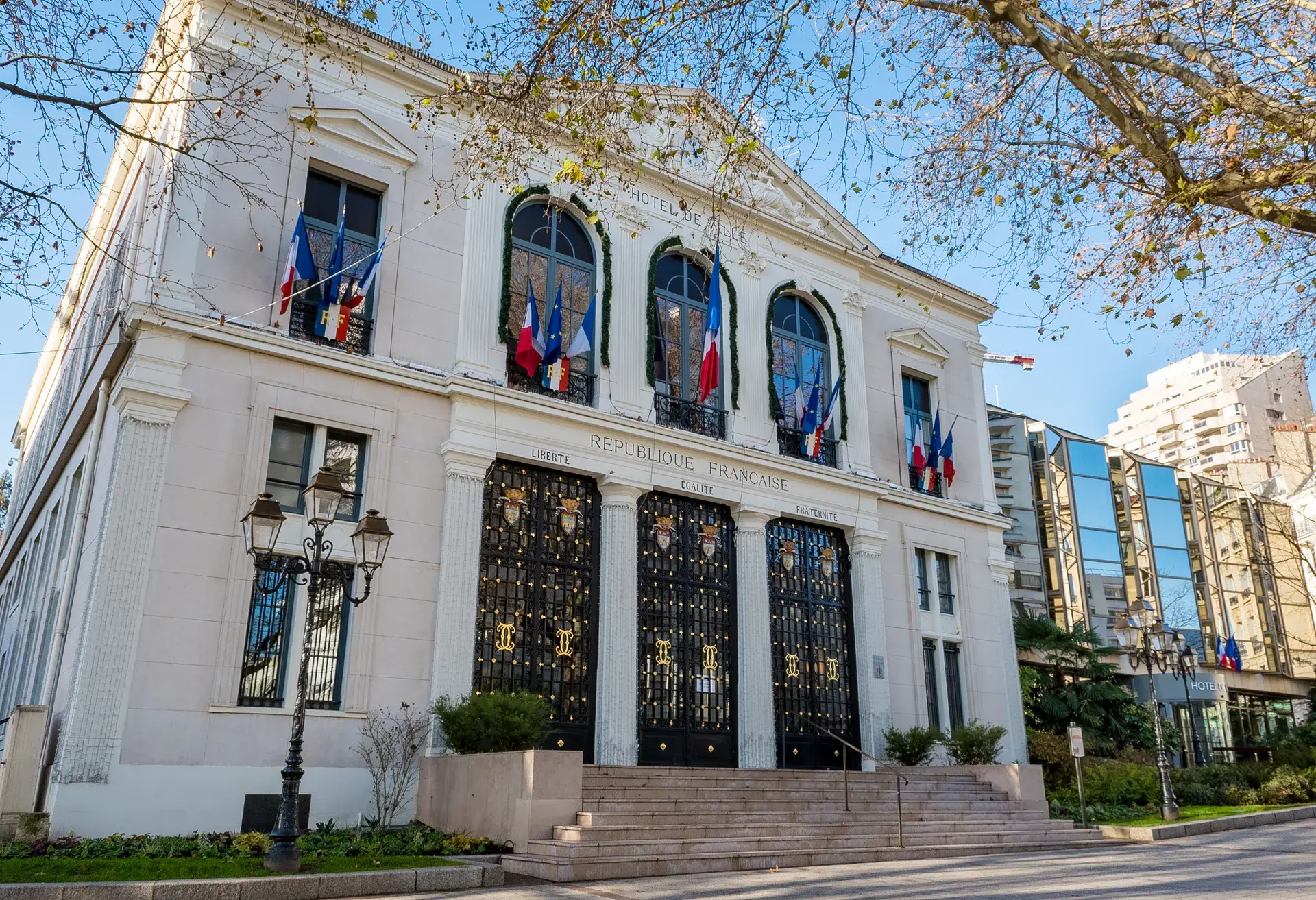 Mairie en pierre pavoisée de drapeaux tricolores, quartier Hôtel de Ville à Courbevoie
