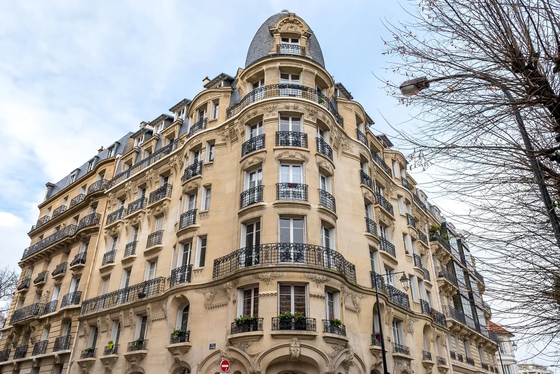 Immeuble haussmannien d'angle à dôme et balcons ouvragés, quartier Les Couronnes à Courbevoie