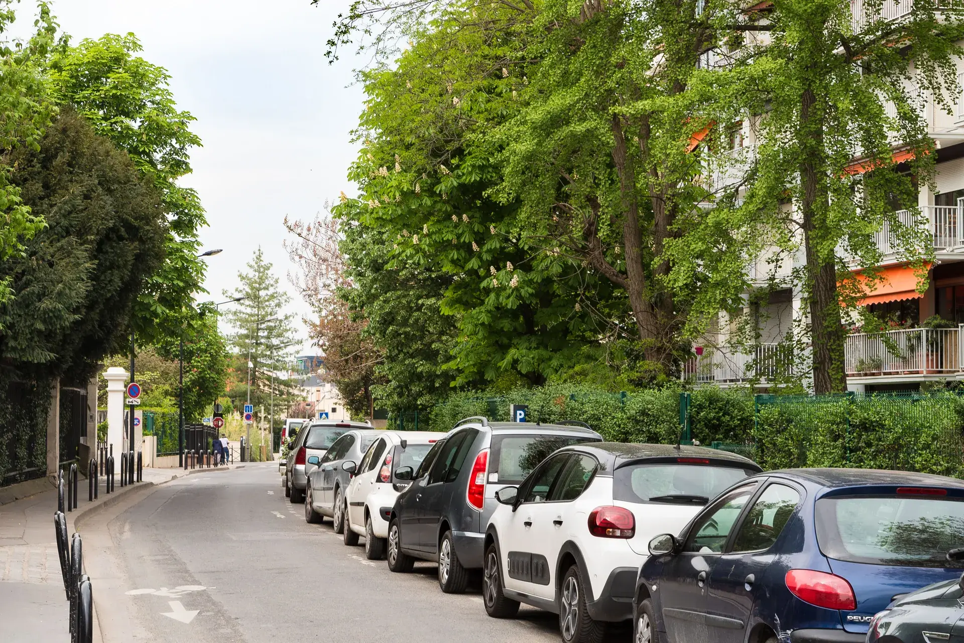 Rue arborée et voitures stationnées le long des résidences, quartier Marceau à Courbevoie