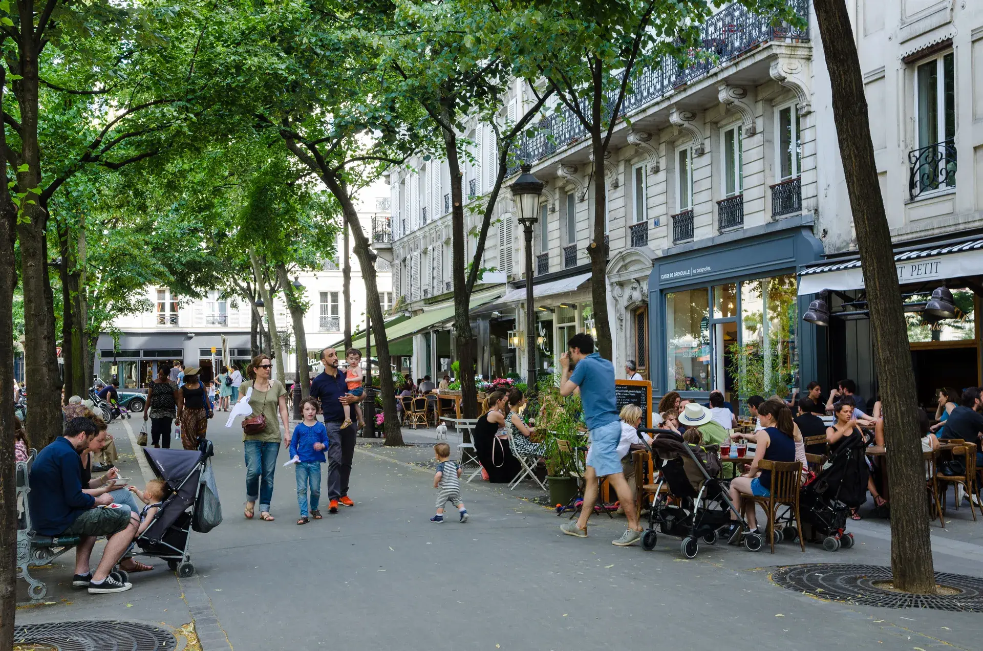 Rue piétonne animée avec terrasses et passants, quartier Batignolles, Paris 17e