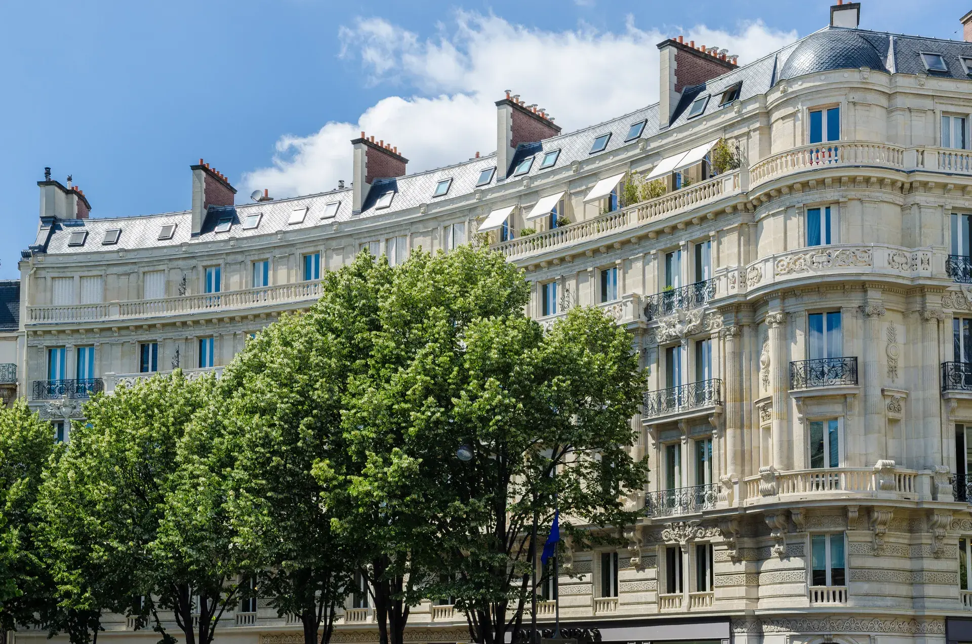 Immeubles haussmanniens clairs derrière des arbres, quartier Courcelles Wagram, Paris 17e