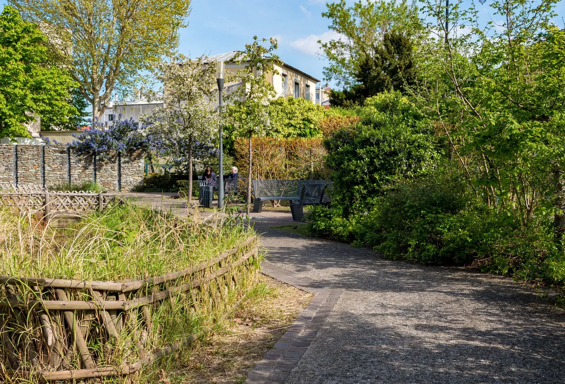 Allée pavée d'un square verdoyant au printemps, quartier Marceau à Courbevoie