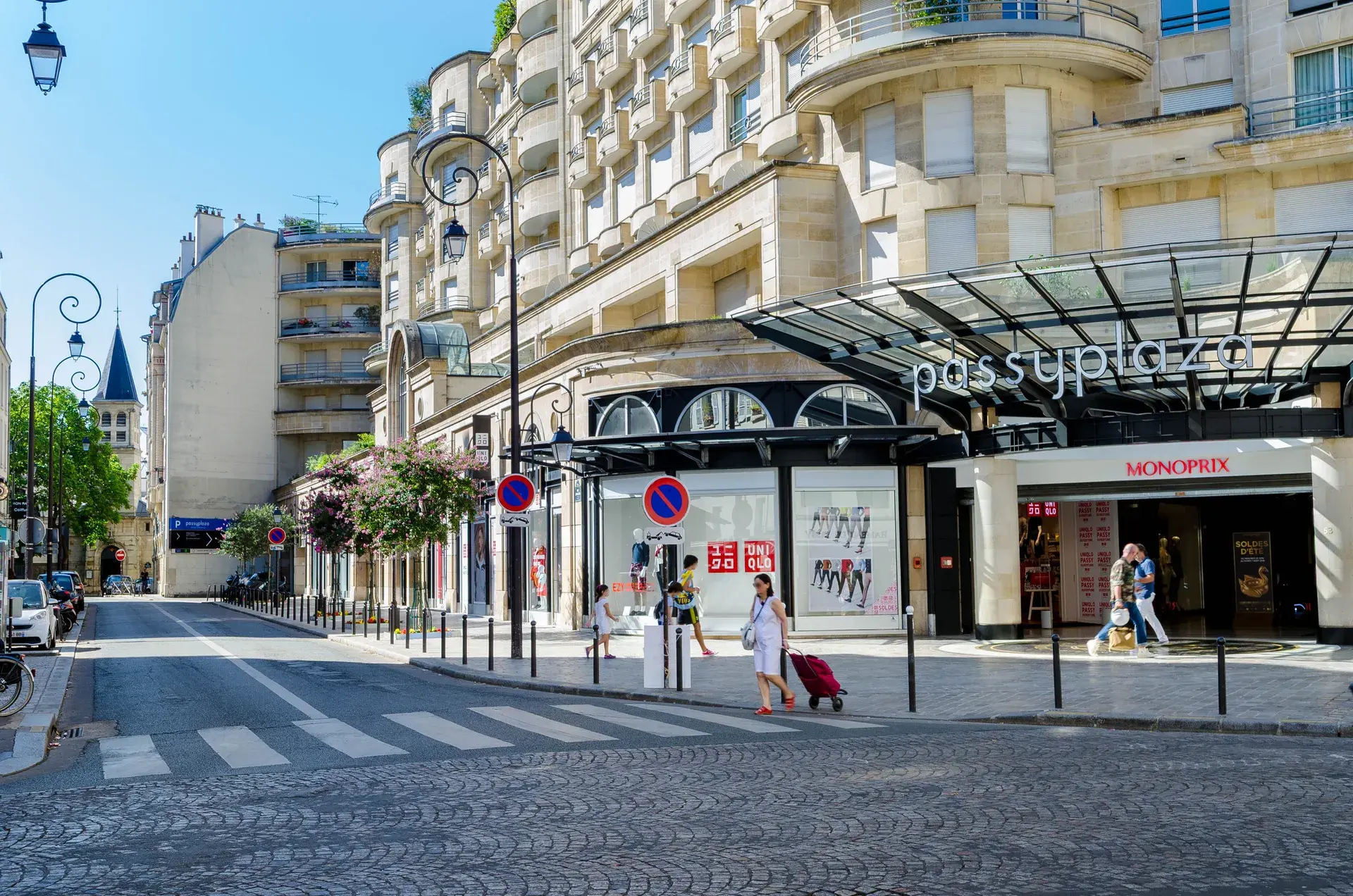 Entrée de Passy Plaza et Monoprix à l'angle d'un immeuble, quartier Village Passy, Paris 16e