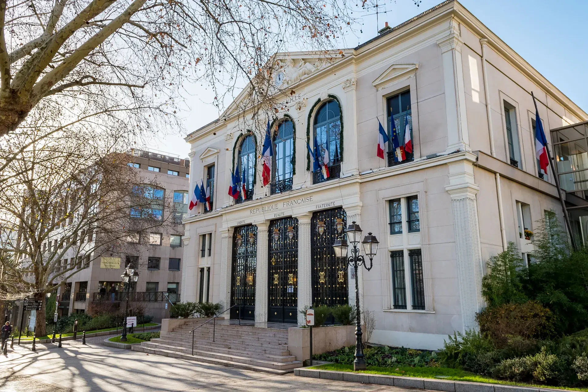 Façade de la mairie ornée de drapeaux français, quartier Hôtel de Ville à Courbevoie