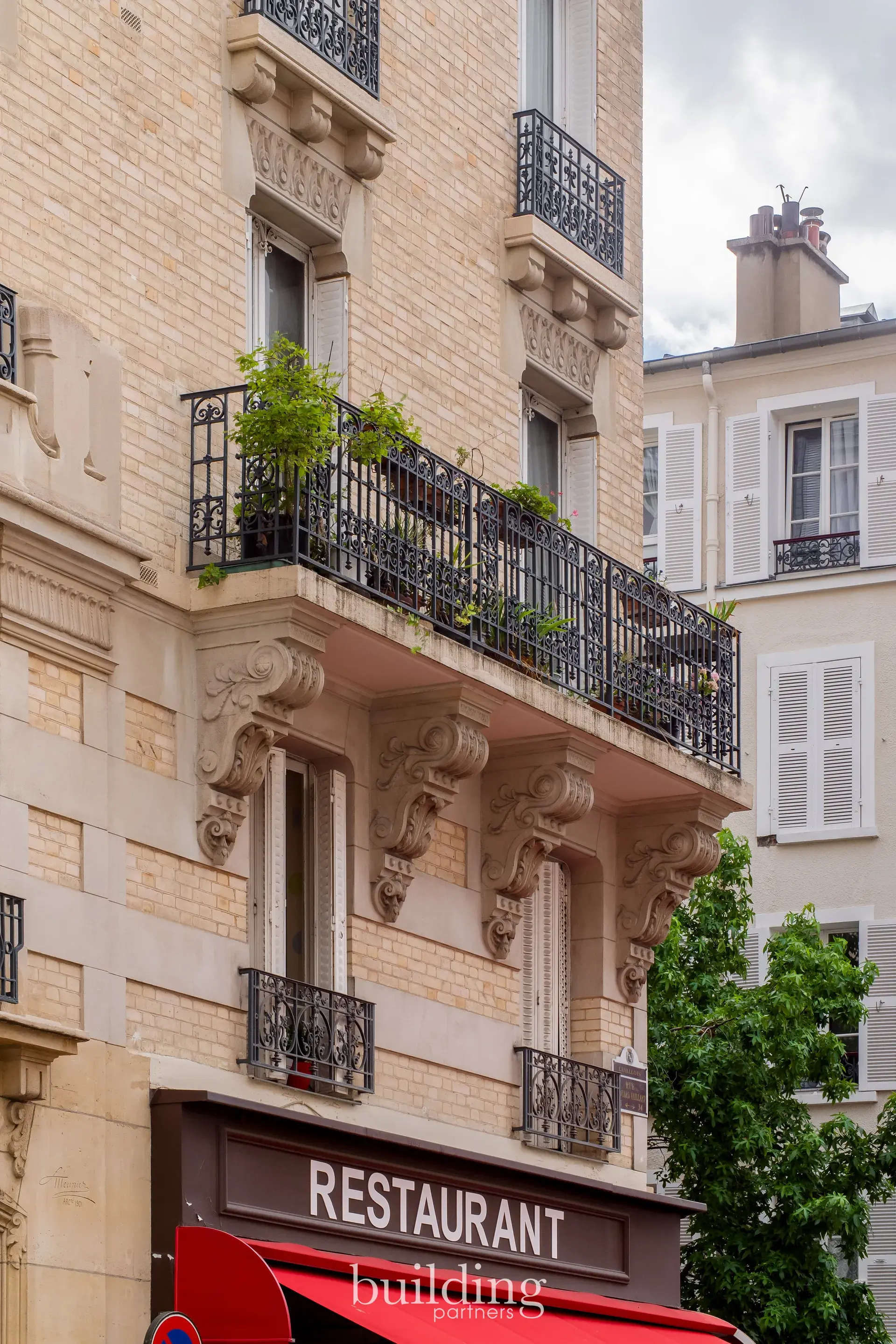 Détail de la façade sculptée d'un immeuble ancien au-dessus d'un restaurant, quartier Mairie à Levallois-Perret