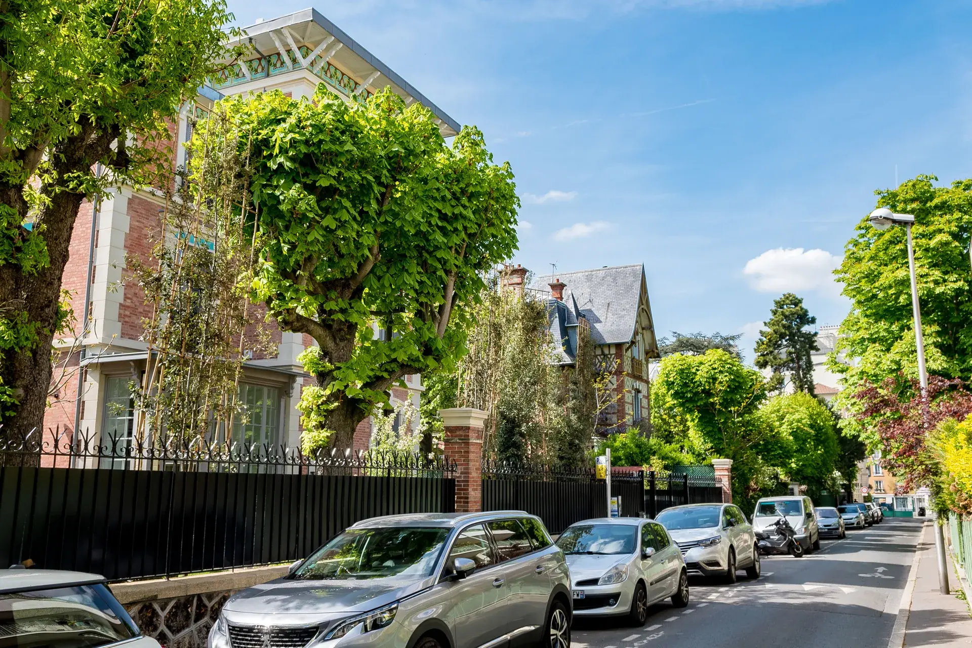 Rue calme aux maisons anciennes couvertes de verdure, quartier Les Couronnes à Courbevoie