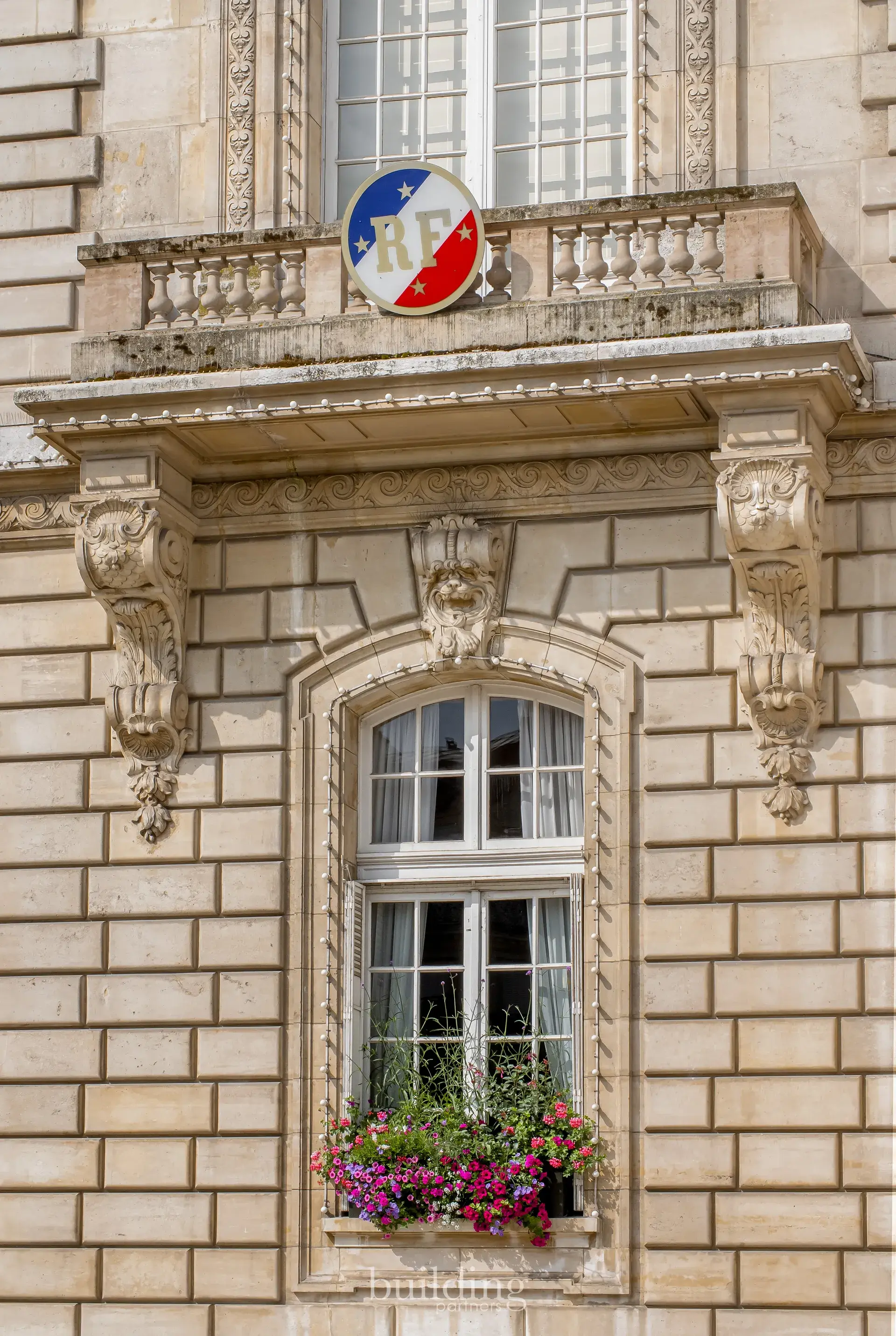 Fenêtre sculptée de l'hôtel de ville surmontée d'une cocarde tricolore, quartier Mairie à Levallois-Perret