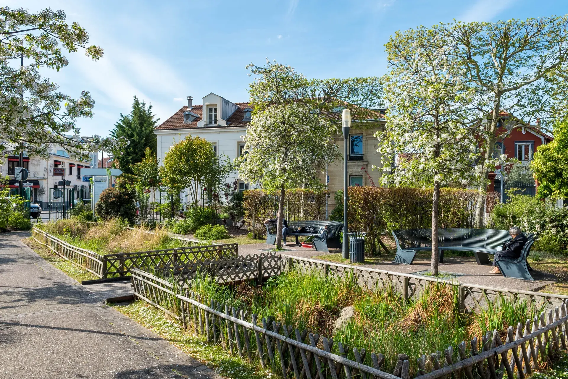 Square fleuri aux arbres en fleurs et bancs ombragés, quartier Marceau à Courbevoie