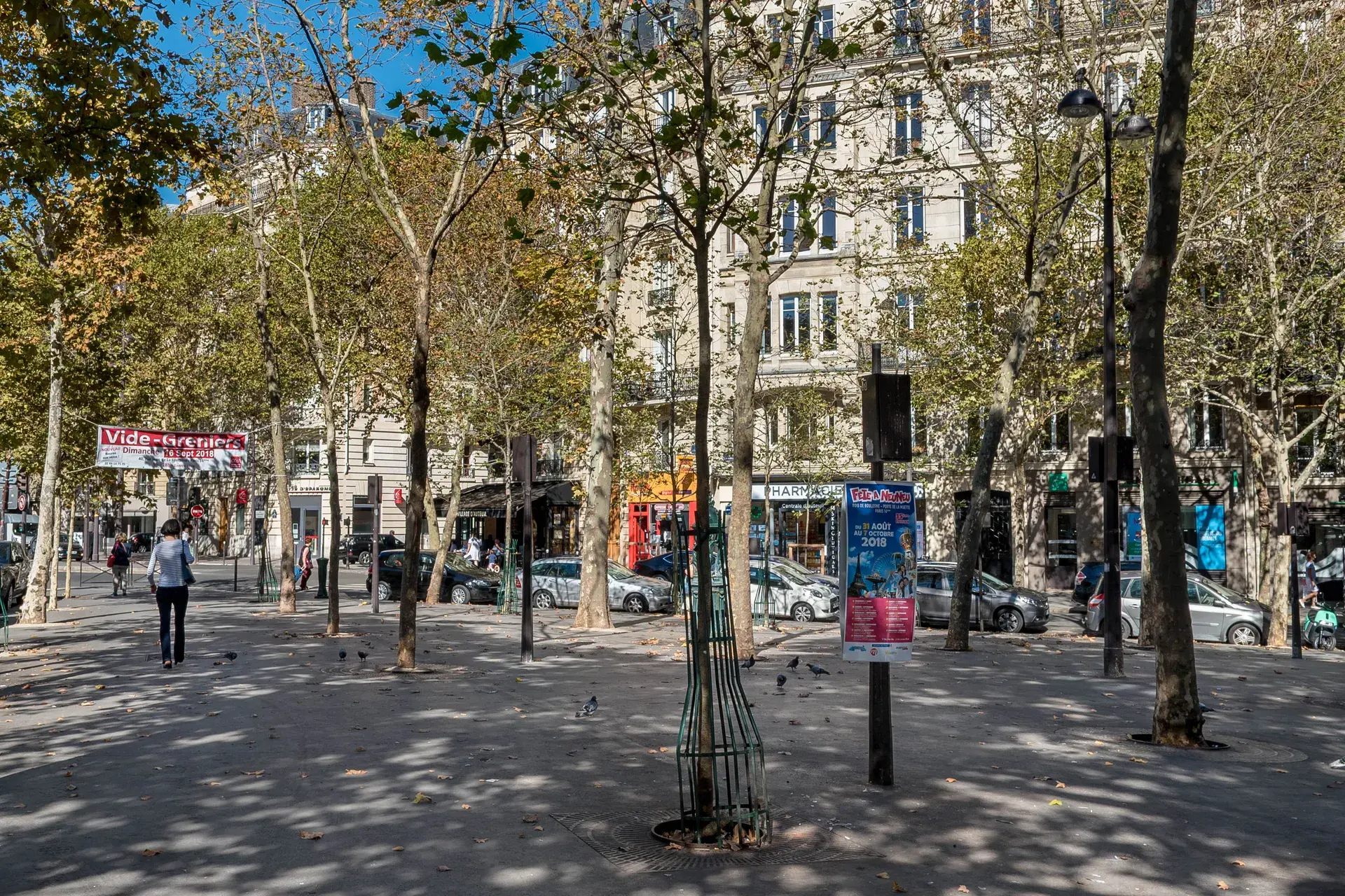 Place plantée de platanes et commerces face aux immeubles, quartier Auteuil, Paris 16e