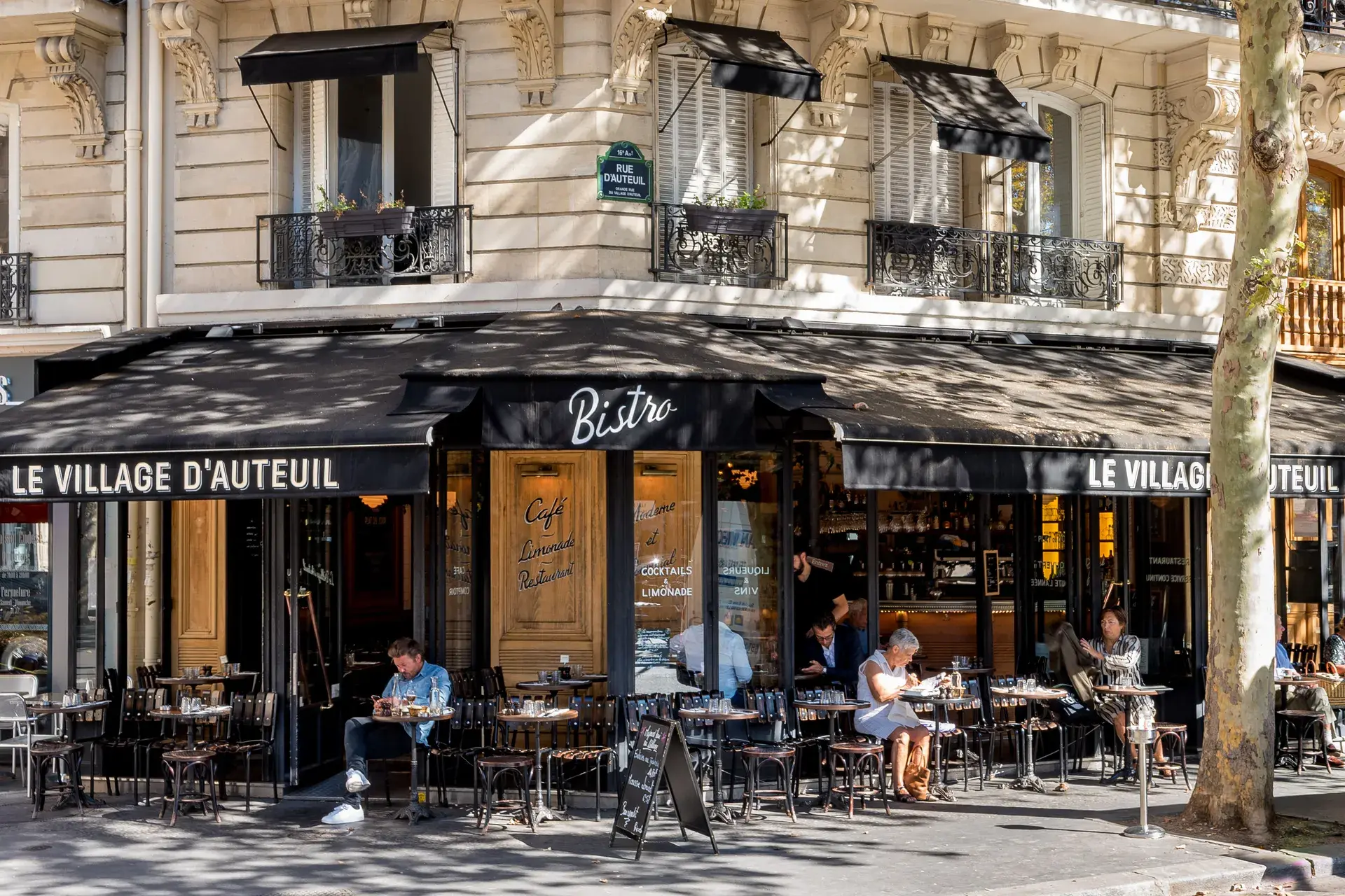 Terrasse du bistro Le Village d'Auteuil au pied d'un immeuble haussmannien, quartier Auteuil, Paris 16e