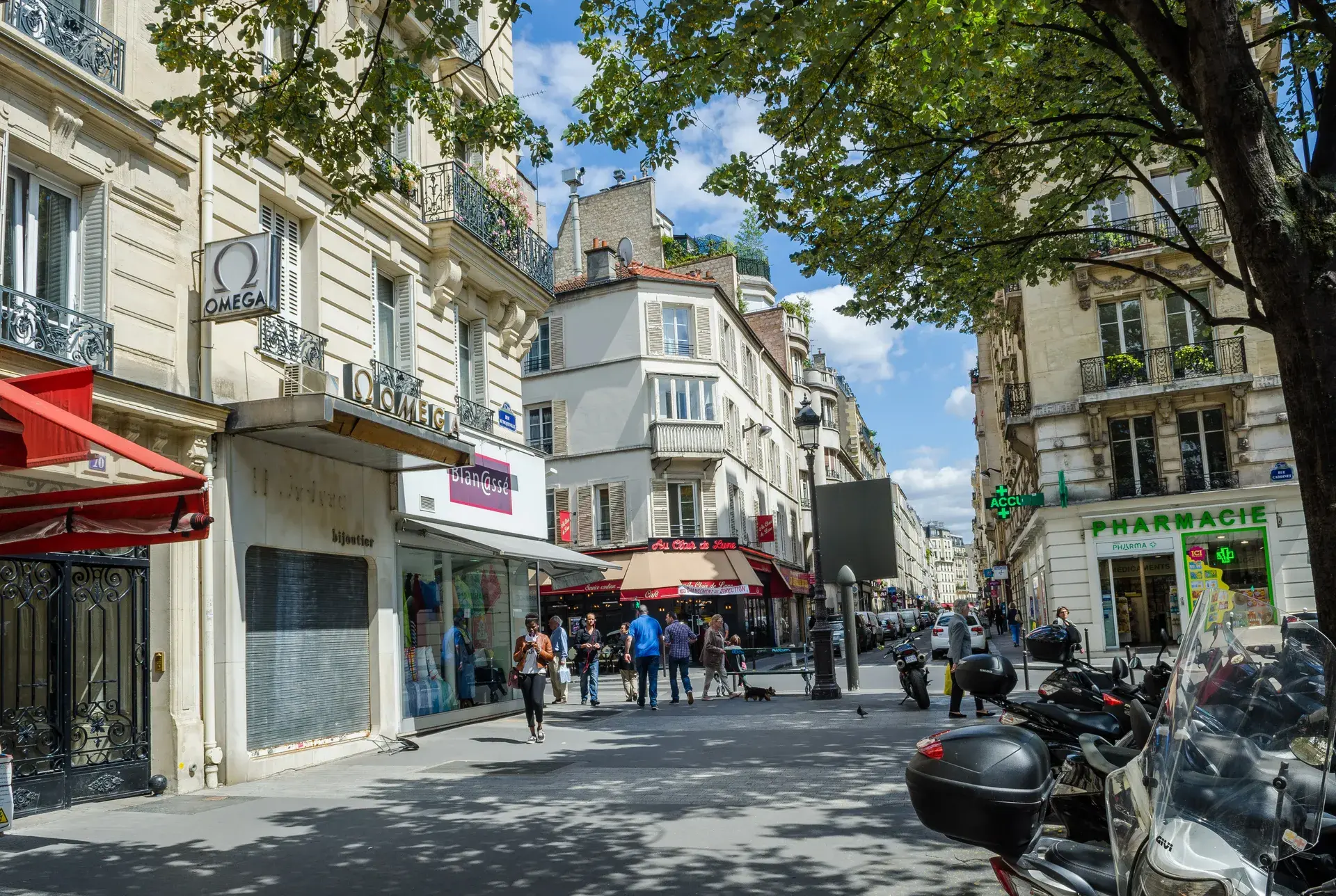 Rue commerçante animée avec boutiques et pharmacie, quartier Légendre-Lévis, Paris 17e