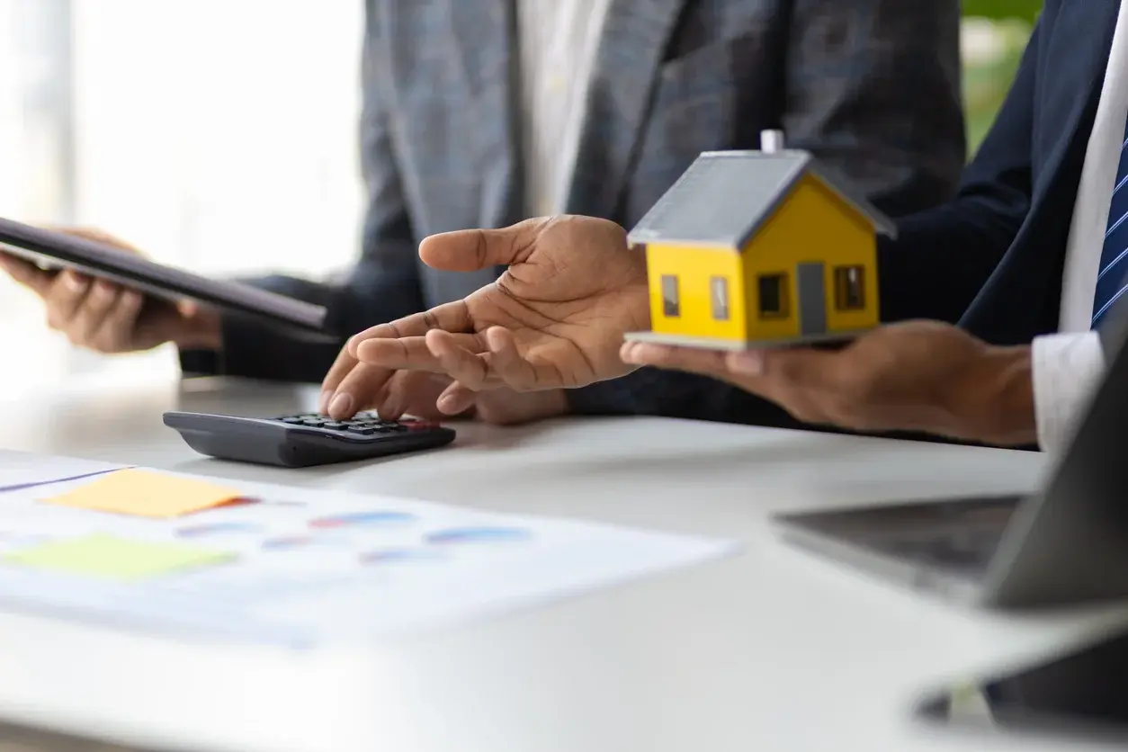 Photo d'agents immobiliers discutant du prix d'un bien avec une calculatrice et des stylos. Comment sont estimés les biens à Levallois-Perret et Neuilly-sur-Seine ? Crédits iStock : Wasan Tita. Référence de la photo : 2163457663.