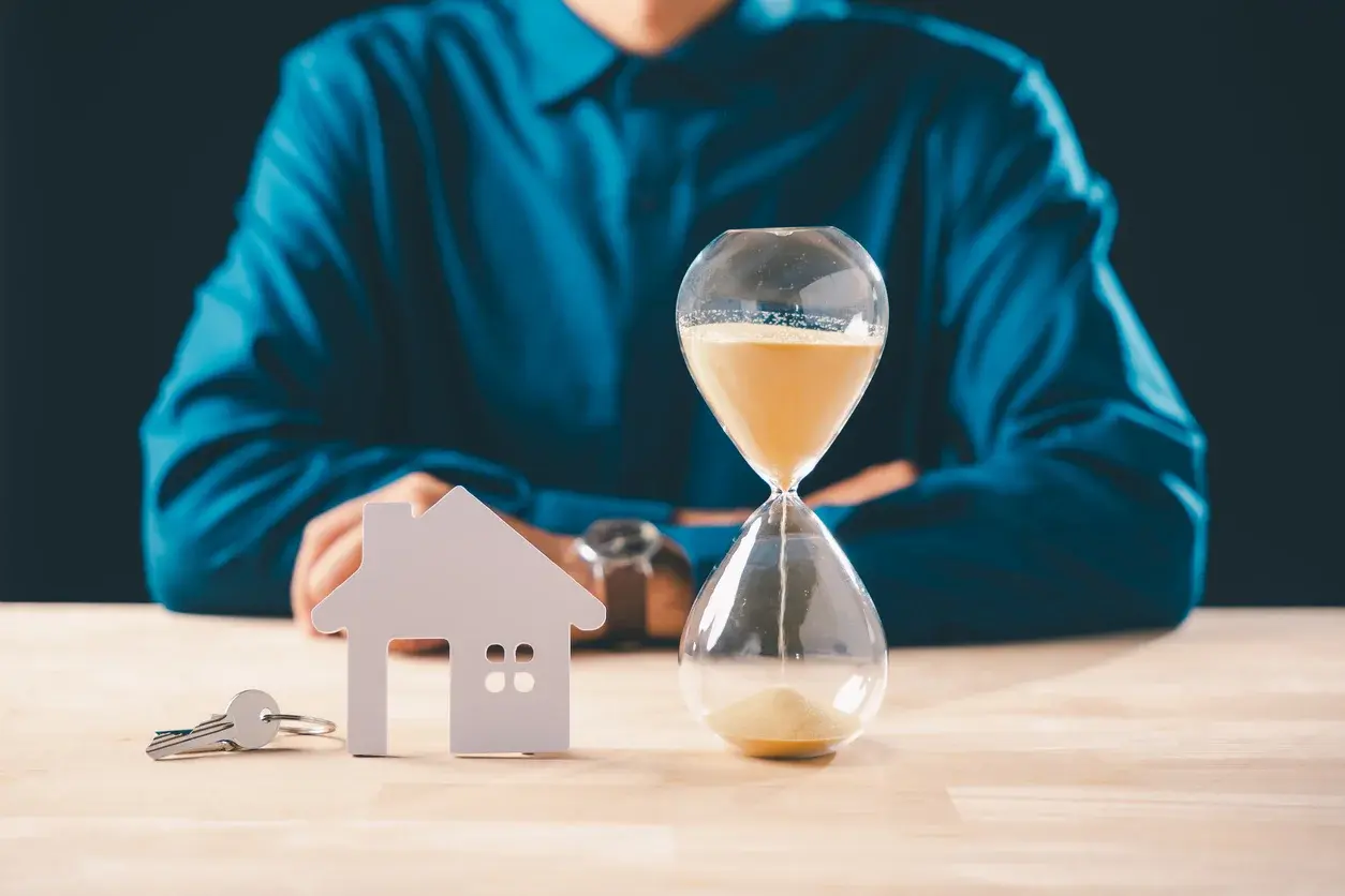 Photo d'un sablier, de clés et d'une maison, utilisée pour un article Building Partners sur les délais, facteurs d'influence et conseils pour accélérer votre vente. Crédits iStock : Sorapop. Référence de la photo : 2255615405.