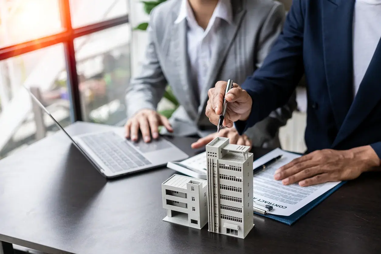 Photo en plongée d'une maison miniature posée sur une calculatrice qui affiche 2026. Elle illustre l'article sur l'état du marché immobilier au printemps 2026 par Building Partners. Crédits iStock :ArLawKa AungTun. Référence de la photo : 1487456402.