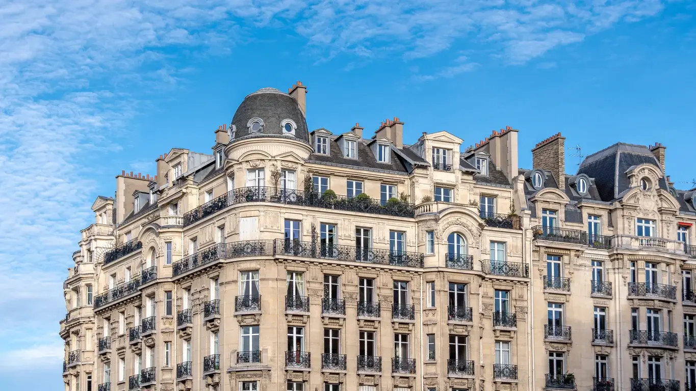 Photo de la vue extérieure des immeubles de style haussmann sur ciel bleu à Paris, France. Utilisée dans l'article Building Partners sur les manières de rénover un appartement haussmannien. Crédits iStock : HJBC. Référence de la photo : 2253788177.